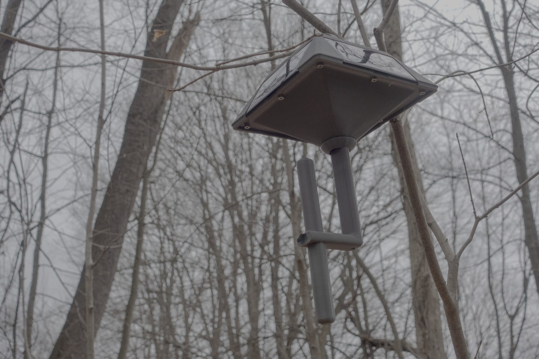 Lantern node installed outdoors with the hanging body and lower stake mount visible.